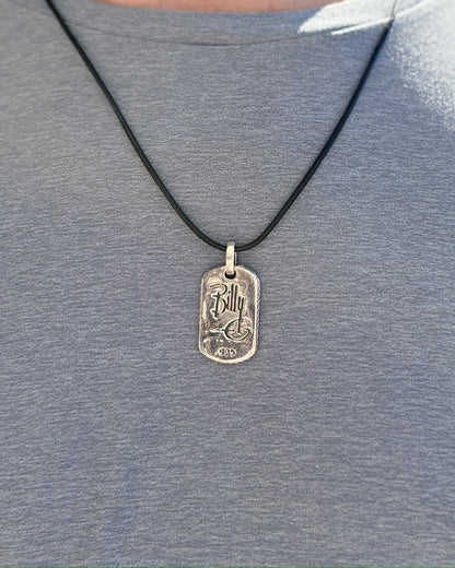Man wearing the Have Mercy pendant on a black leather cord over a gray t-shirt, back view with Billy G signature and .925 stamp