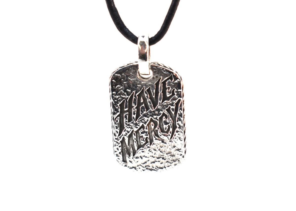 Have Mercy pendant on black leather cord, slightly angled front view showing hammered texture